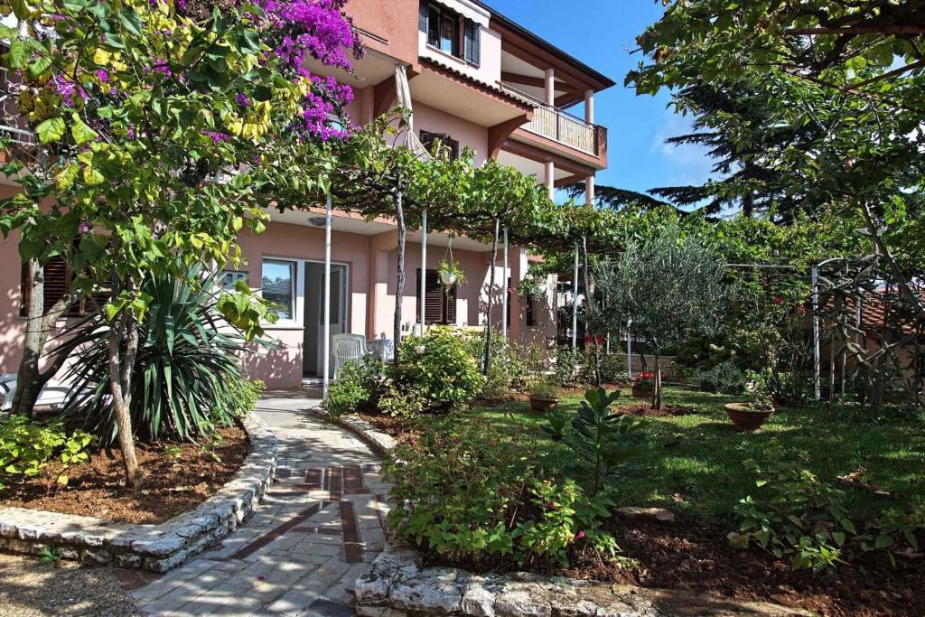 a garden in front of a house with flowers at Apartment in Pula - Istrien 17321 in Vintijan
