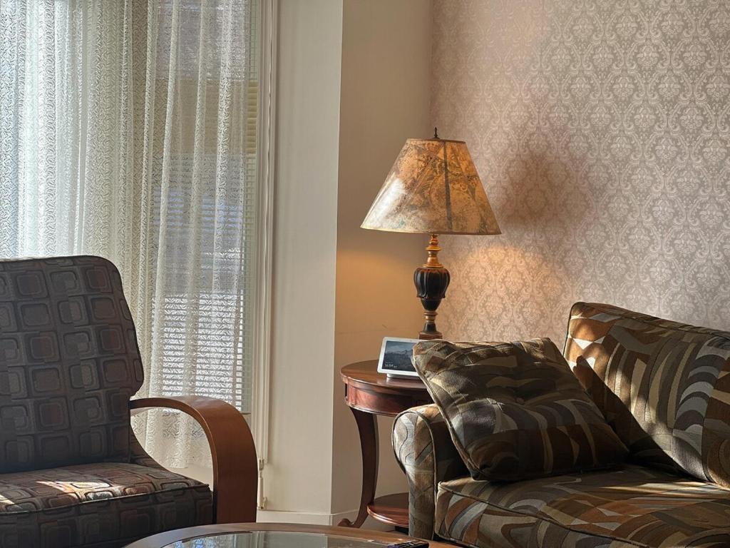 a living room with a couch and a table with a lamp at Entire 6BED house easy to Banff & DT, Winsport in Calgary