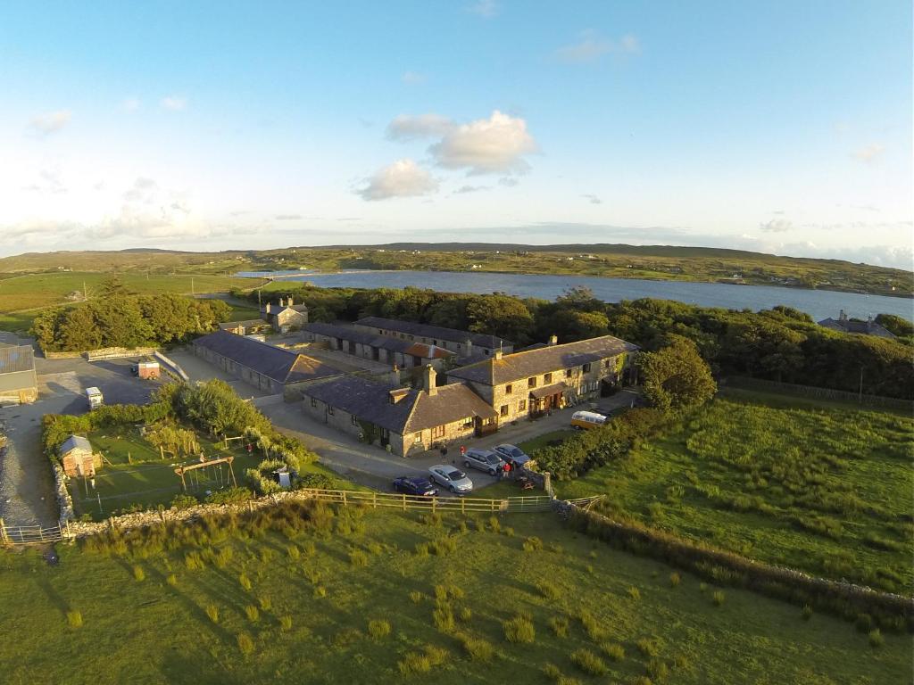 an aerial view of a large house with a lake at Cleggan Farm Holiday Cottages in Cleggan