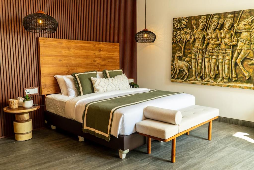 a bedroom with a large bed and a painting on the wall at Villa Samudra, Luxury and Comfort Villa by Balian Beach in Mantaak