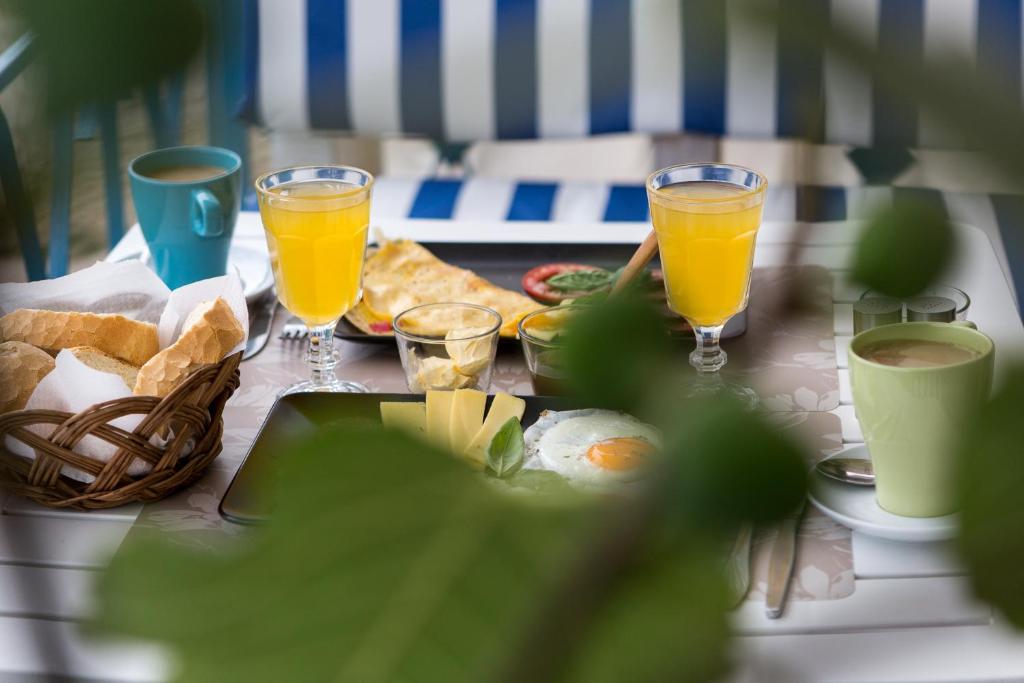 a table with a plate of food and two glasses of orange juice at Guest house Mediterranea in Pakoštane