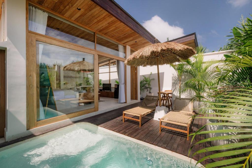 a house with a swimming pool and a patio at Tula Collective Uluwatu in Uluwatu