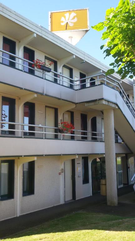 an external view of a building with a balcony at Premiere Classe Cambrai Proville in Cambrai