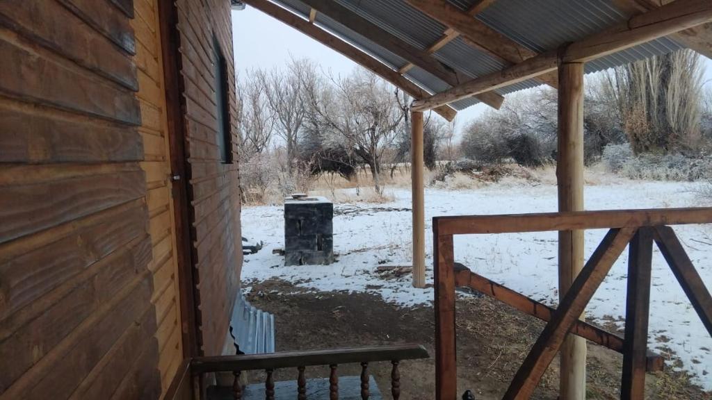 a snow covered porch with a bench next to a building at Cabaña La 40 "Relax y descanso en zona de chacras" in Buta Ranquil