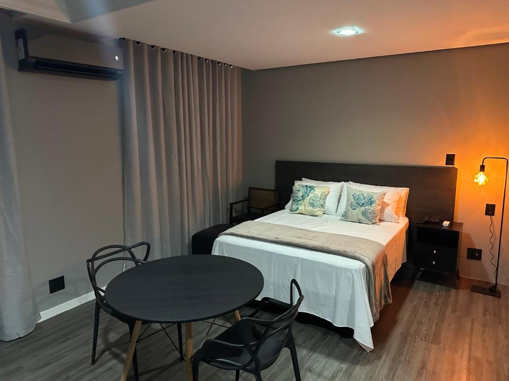 a bedroom with a bed and a table and chairs at Manaus Hotéis Millenium - Flat 804 in Manaus