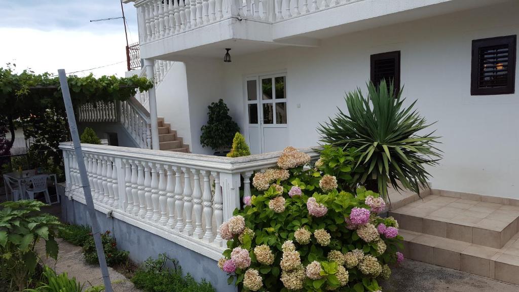 een wit huis met een witte leuning en bloemen bij Draskovic's House in Bar