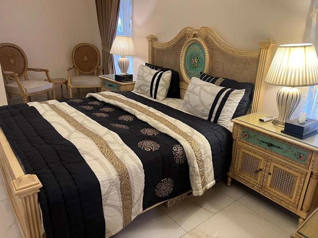 a bedroom with a bed with a black and white comforter at CDA Park Enclave a tastefully furnished property ! in Islamabad