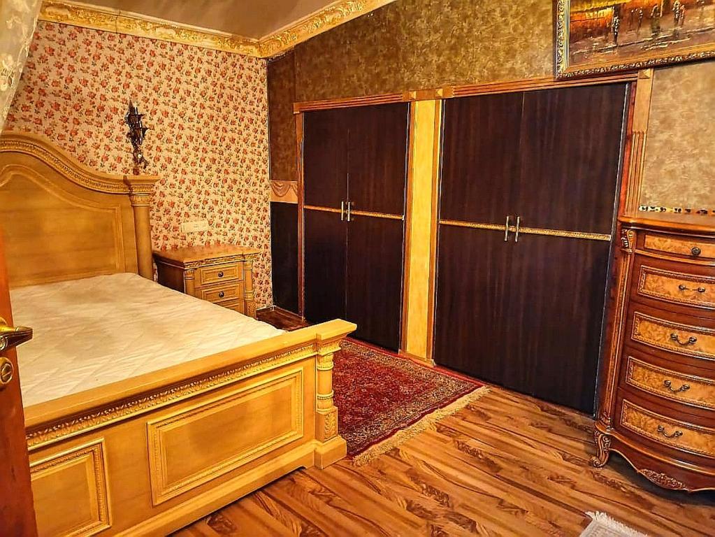 a bedroom with a bed and a dresser in it at Dzoraghbyur "Garden Paradise" in Vokhchaberd