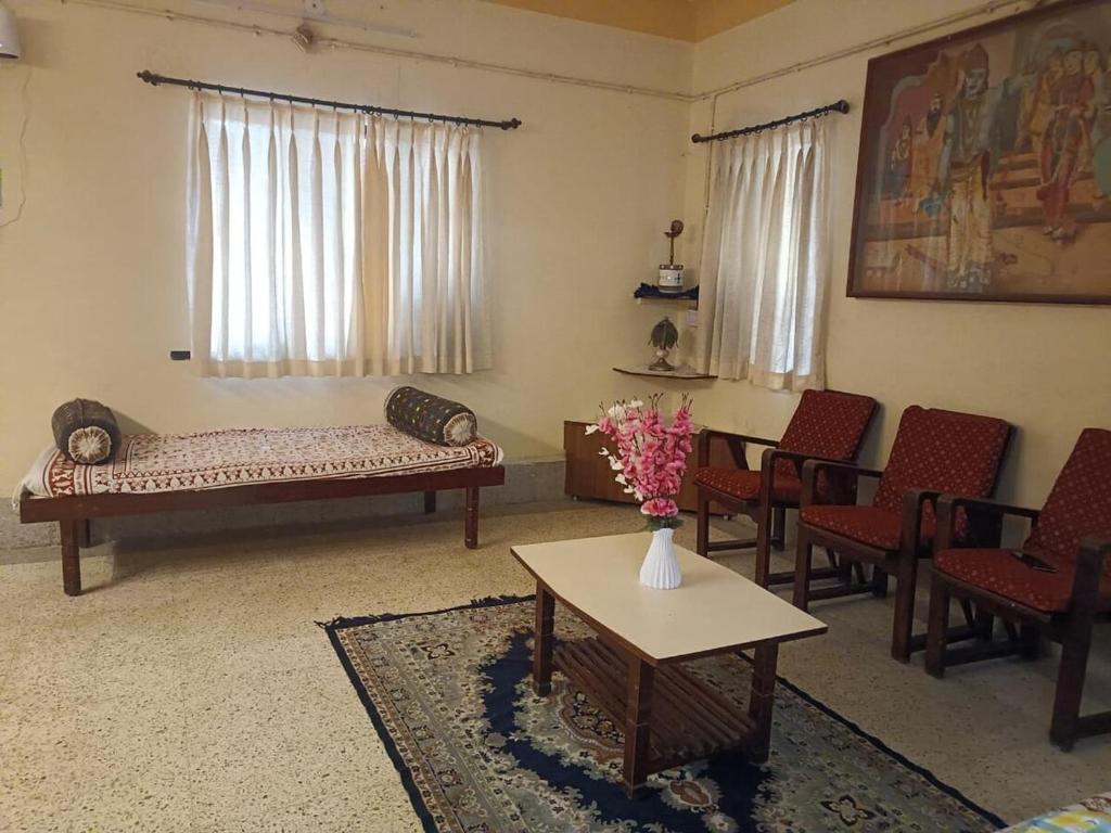 ein Wohnzimmer mit Sofa, Stühlen und einem Tisch in der Unterkunft Esha's Homely stay in Indāpur
