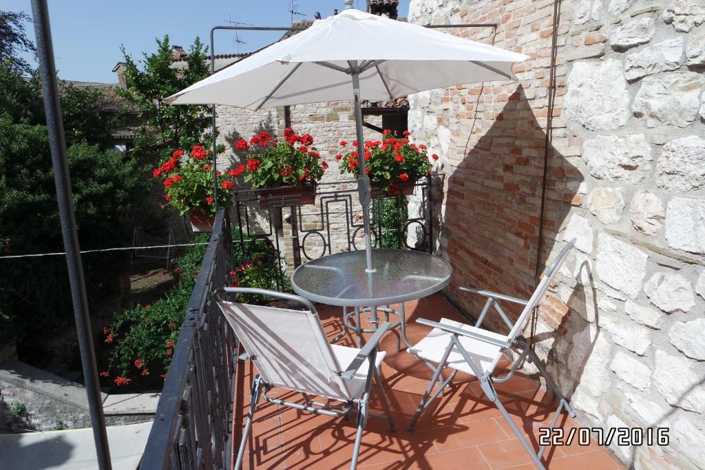 グッビオにあるIl Terrazzino Nel Cuore Di Gubbioのテーブルと椅子、バルコニー(パラソル付)