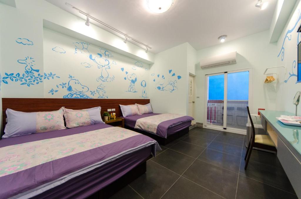 2 camas en una habitación con paredes azules y blancas en Good Mood Cottage en Hengchun Old Town