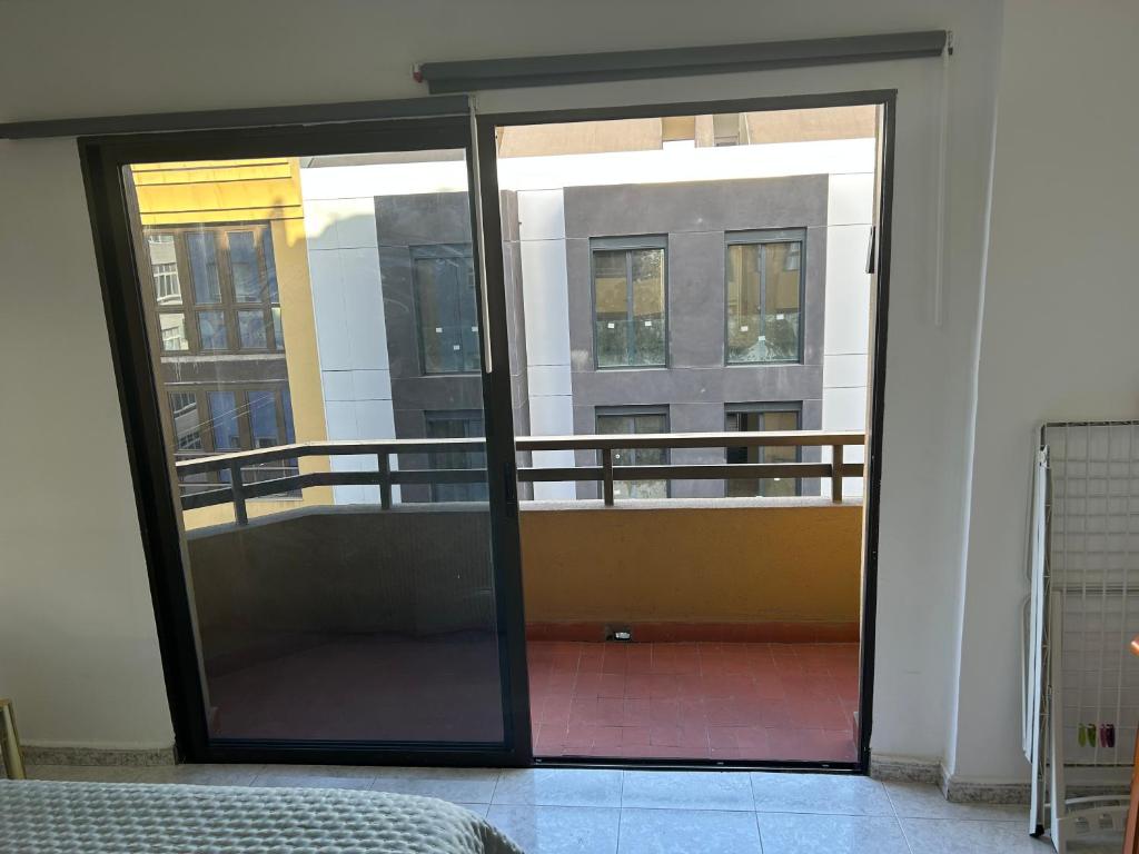 an open glass door with a balcony in a building at Apartamento Las Canteras in Las Palmas de Gran Canaria