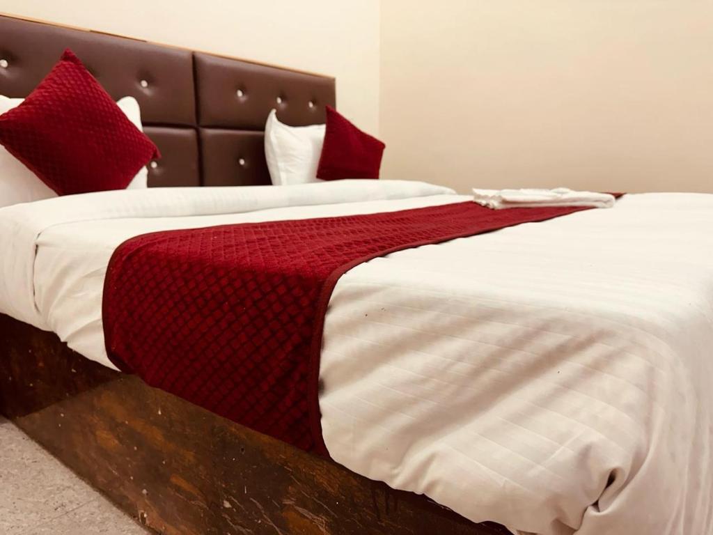a bedroom with two beds with red pillows at WooibHotels Krishna Residency Vrindavan in Vrindāvan