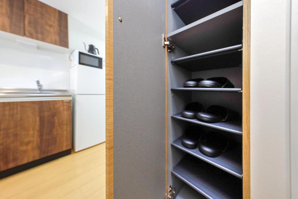 a closet with black shoes in a kitchen at Oakville Nezu by Tranova in Tokyo