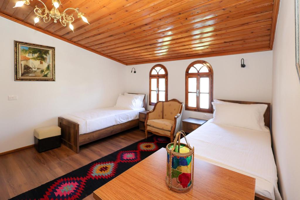 a bedroom with two beds and a chair and a table at Villa Starova in Berat