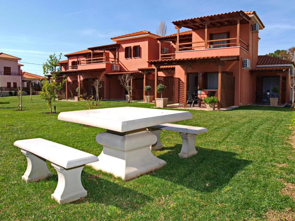 a picnic table and benches in front of a house at Melograno in Kala Nera