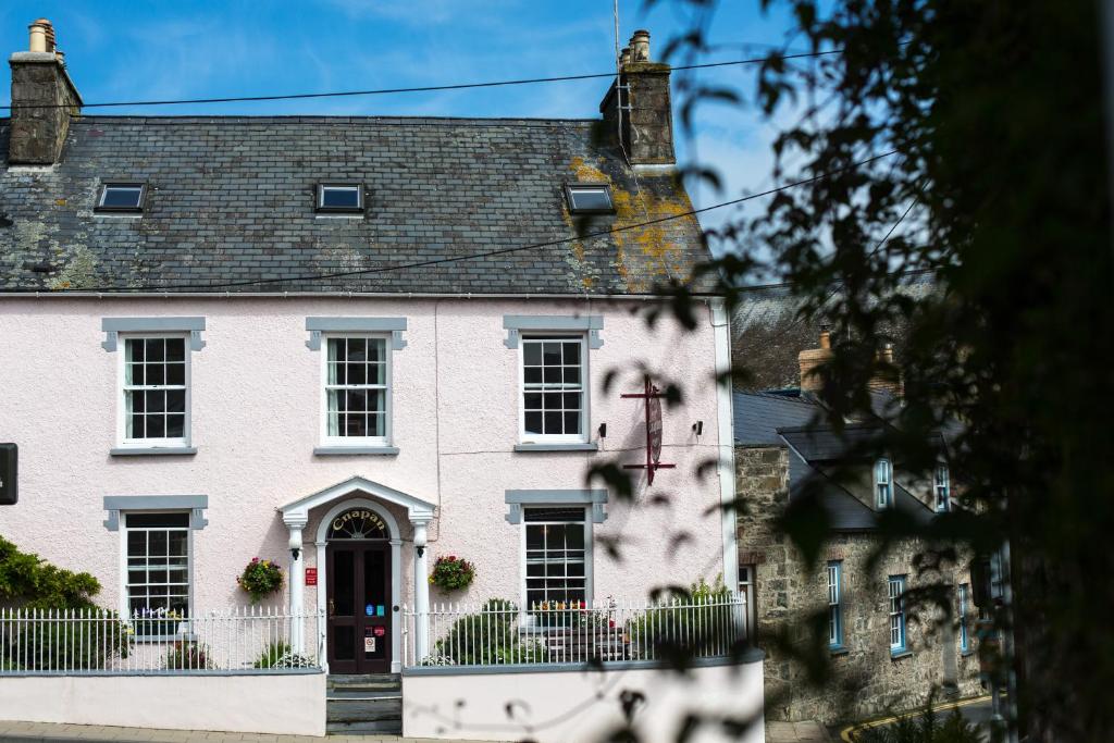 ein weißes Haus mit einer roten Tür in der Unterkunft Cnapan Guest House in Newport