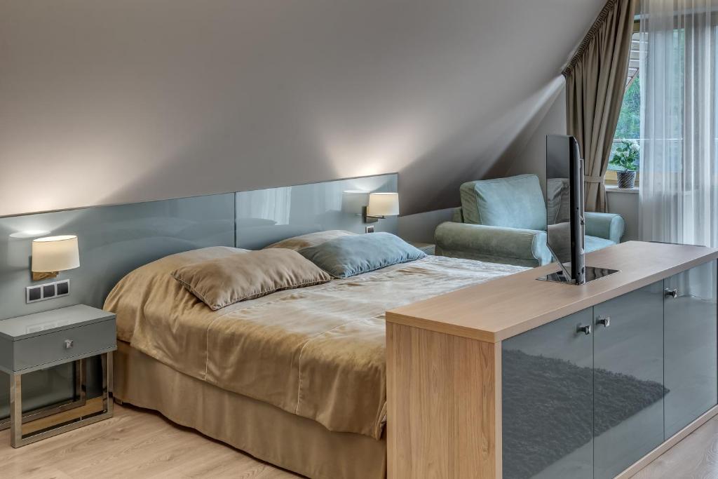 a bedroom with a bed and a desk with a television at Villa Wierchy in Zakopane