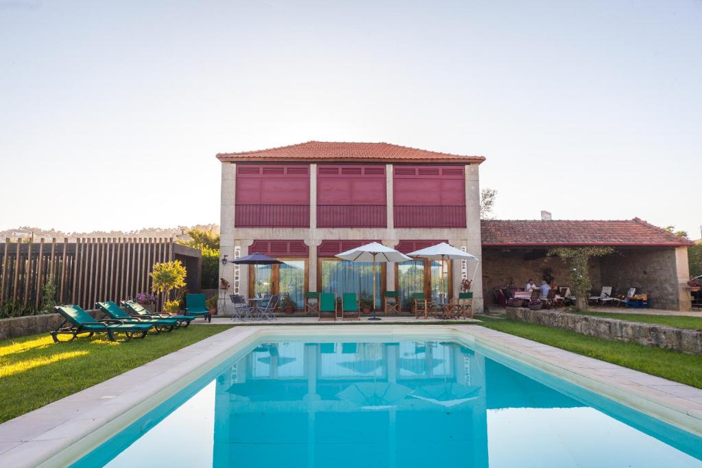 uma casa com piscina em frente a uma casa em Casa do Varandão em Barcelos