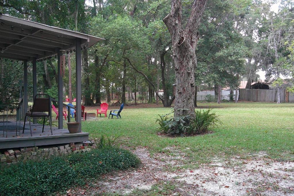 a gazebo with chairs and a tree in a yard at Moody Woods in Orange Park