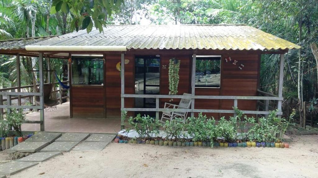 una pequeña casa de madera con techo de estaño en Amazon Hostel & Eventos en Iranduba