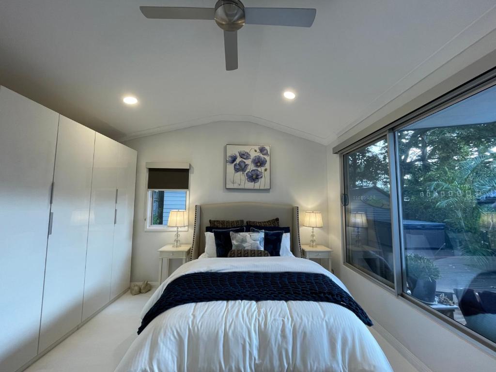 a bedroom with a bed and a large window at Coral Cove in Narrabeen