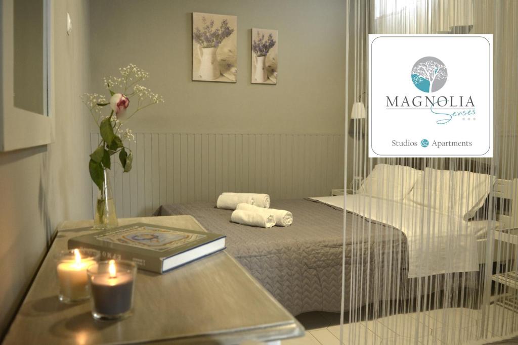 キニオンにあるMagnolia Sensesのベッド1台、キャンドル付きテーブルが備わる小さな客室です。