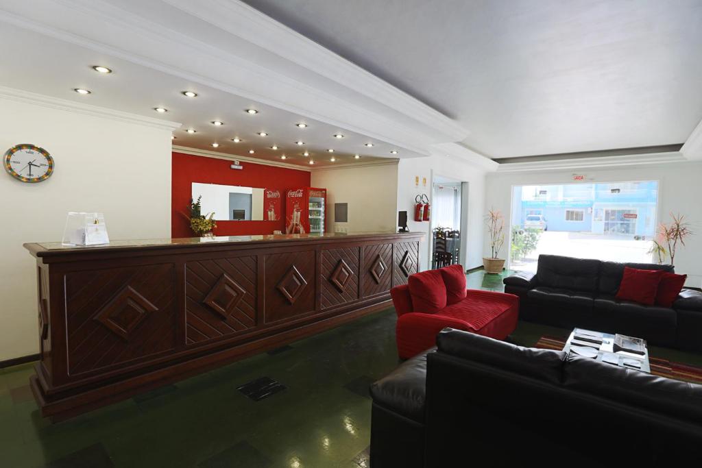 uma sala de estar com um sofá e um bar em Oceano Hotel de Barra Velha em Barra Velha