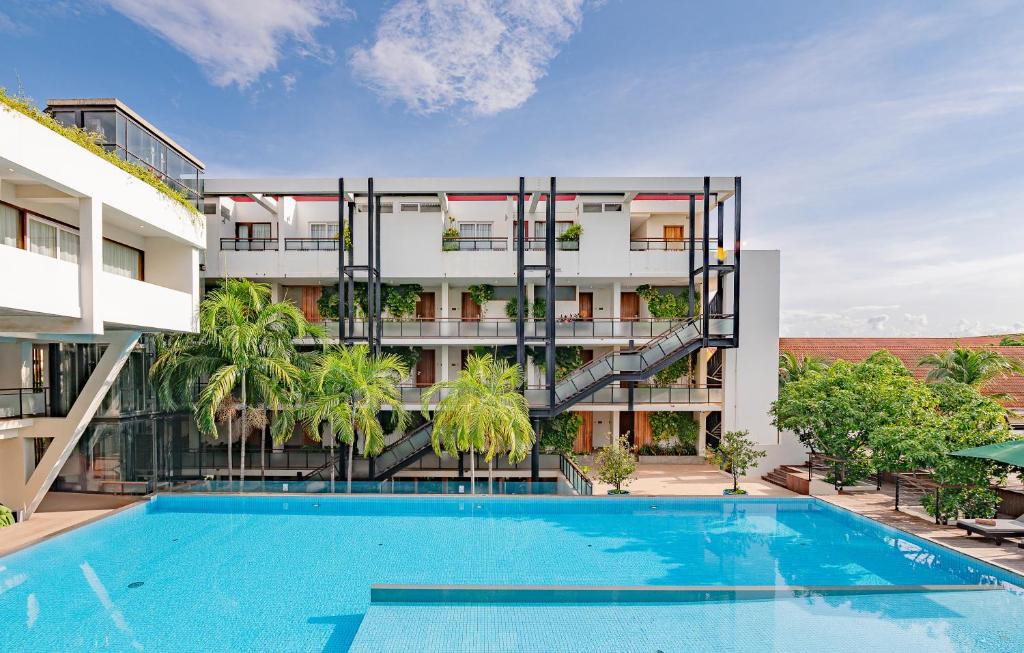 an apartment with a swimming pool and a building at Somadevi Residence in Siem Reap