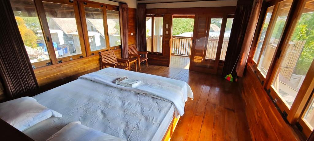 Un dormitorio con una cama en una habitación con ventanas. en Juna Bungalow, en Gili Air