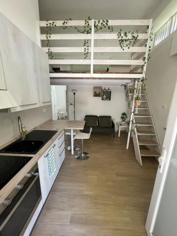a kitchen with a table and a staircase in a room at Small apartment in center in Montesilvano