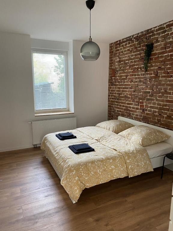 a bedroom with two beds and a brick wall at Heart of Essen in Essen