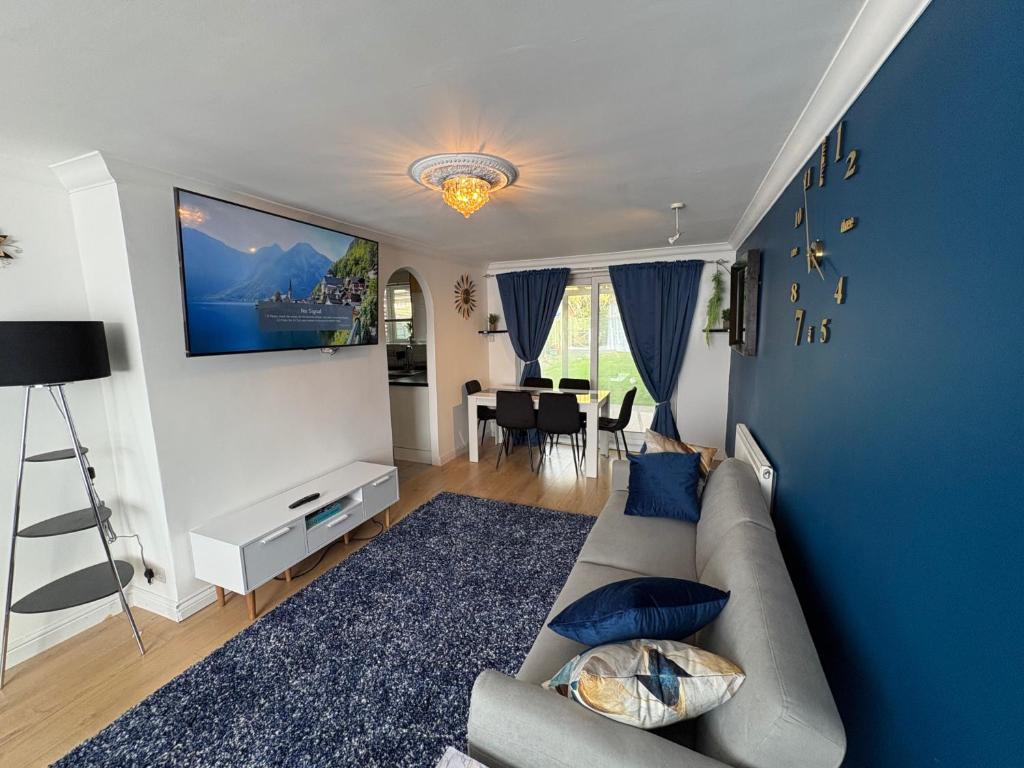 a living room with a couch and a blue wall at Modern and Spacious 3 Bed retreat - Bracknell in Easthampstead