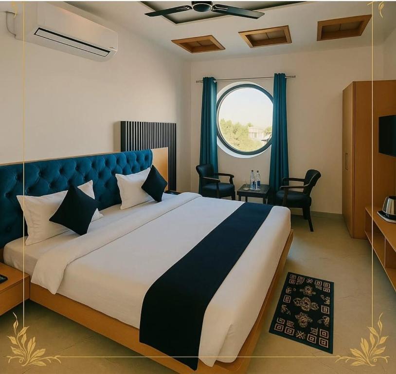 a bedroom with a large bed and a window at Hotel Neel Regency in Kurukshetra