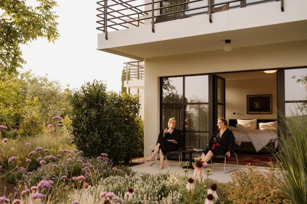 two women sitting in chairs in front of a house at Boutique-Hotel maison 41 - Adults Only in Bad Gleichenberg