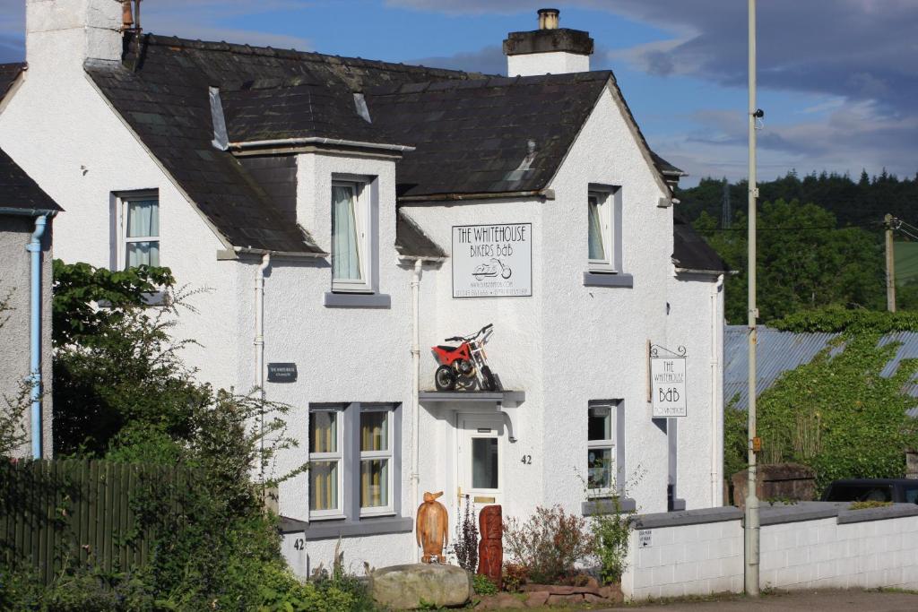 een wit huis met een motor erop bij The Whitehouse in Dingwall