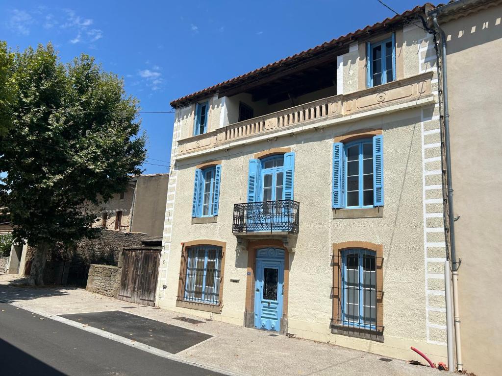 an old building with a blue door on a street at La ou je t emmenerai in Laure-Minervois
