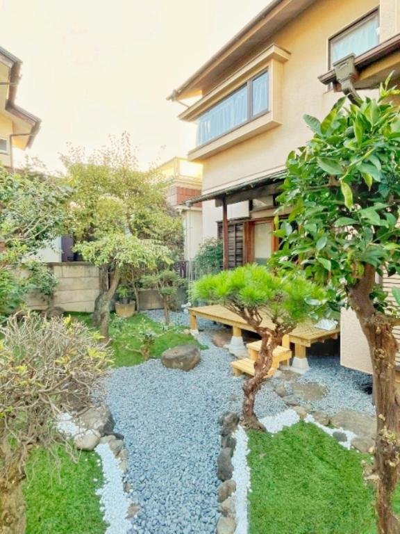 a garden with a wooden bench in a yard at Japan Harry Potter 5min Walk Guesthouse 東京ハリーポッターまで徒歩5分の民宿 in Tokyo