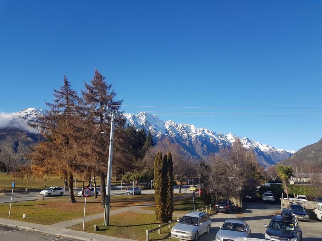 a parking lot with cars parked in front of a mountain at Remarkable studio,close to airport in Queenstown