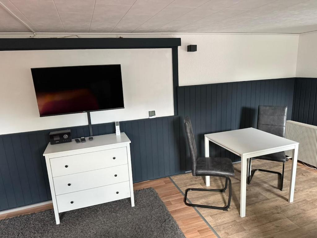 a room with a desk and a table and a tv at Apartment Heidchen in Knüllwald