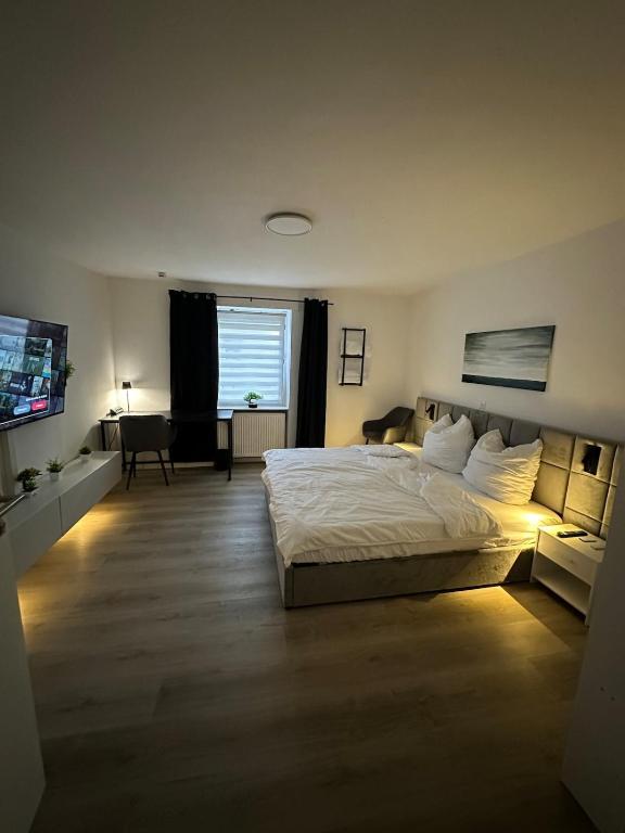 a bedroom with a large bed and a television at Fresh 2 Room Appartment near to Baden-Baden in Baden-Baden