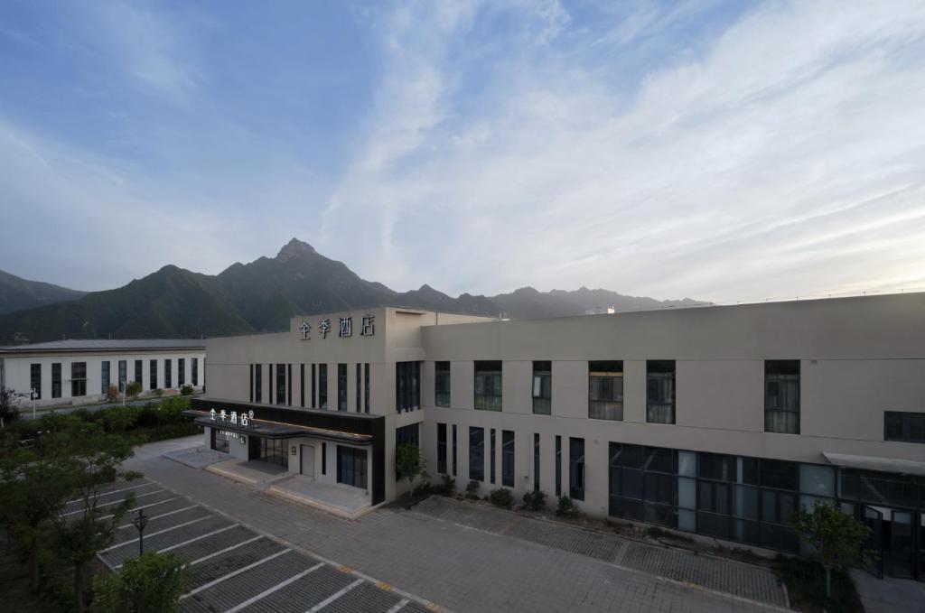 een groot wit gebouw met bergen op de achtergrond bij JI Hotel Xi'an High-tech Caotang BYD Second Factory in Fengyukou