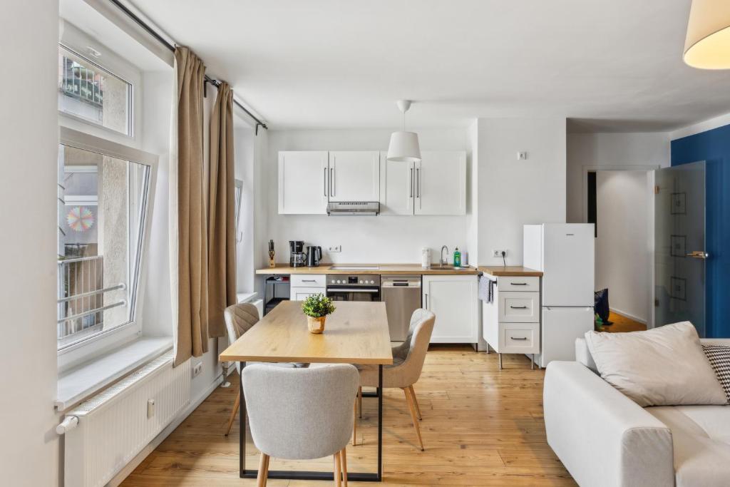 une cuisine et un salon avec une table et un canapé dans l'établissement Erholsame Wohnung mit Balkon und Einbauküche im Herzen Leipzigs, à Leipzig