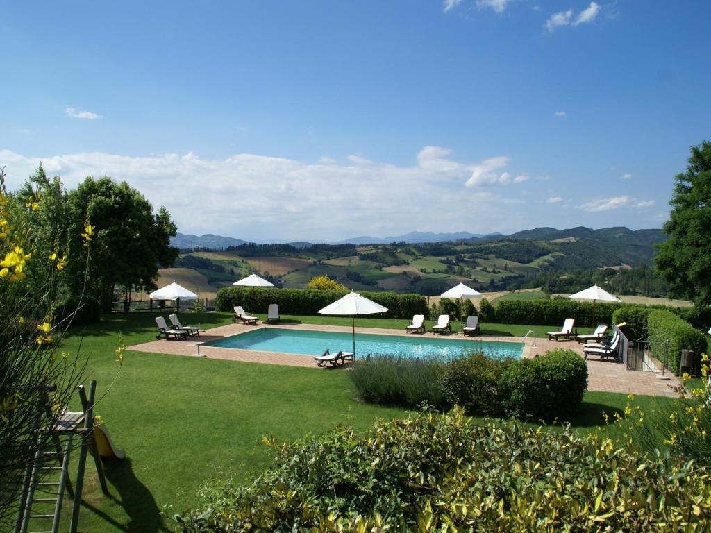 a pool with chairs and umbrellas in a yard at Holiday Home in Montone with Pool & Terrace in Montone