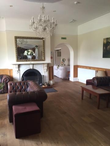 uma sala de estar com um sofá e uma lareira em Leeford Place Hotel em Battle