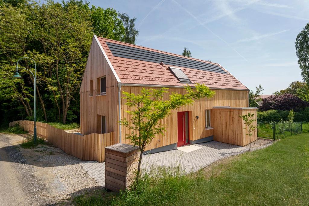 a wooden barn with a red door and a fence at Am Grassnitzberg in Grassnitzberg