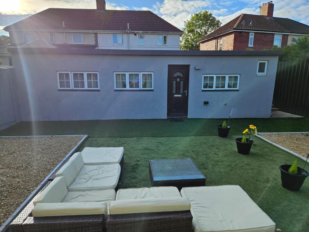a backyard with a white couch and a house at Our beautiful little house makes you stay magical in Bristol
