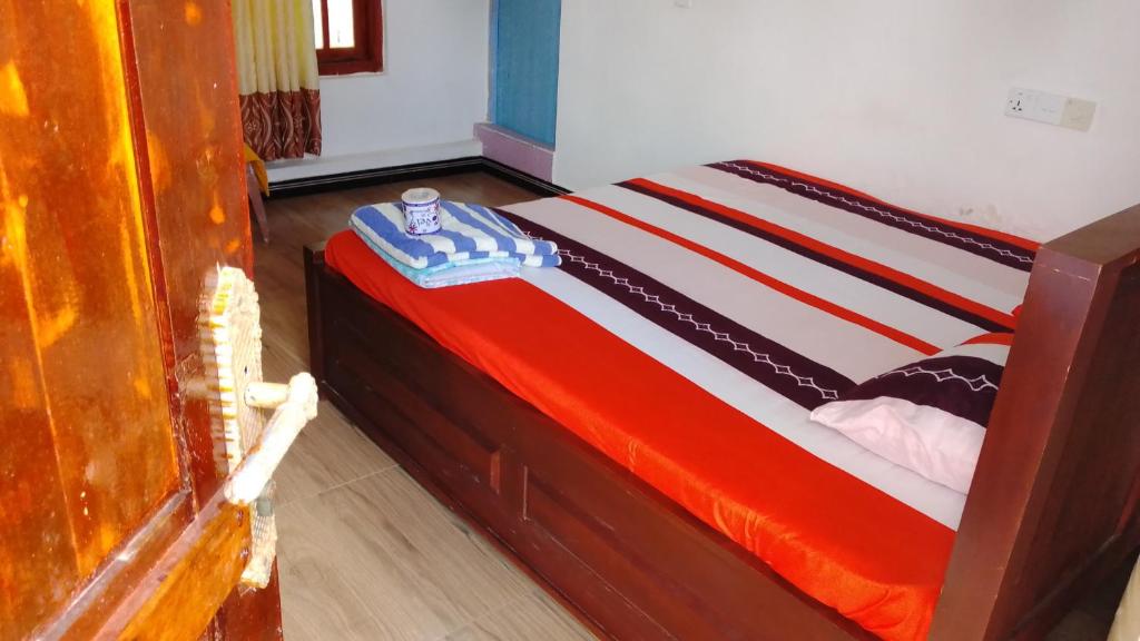 una camera con un letto con una coperta rossa e blu di Hummus Bay Arugam ad Arugam