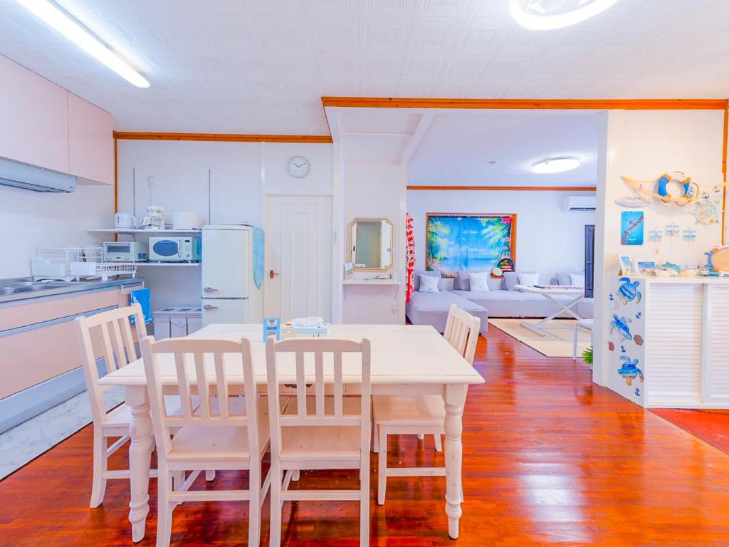 a kitchen and dining room with a table and chairs at 琉球乃風-プチョヘンザ- in Uruma