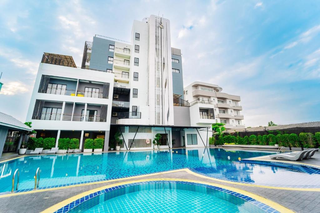 a swimming pool in front of a building at Shewin de Bangkok in Ban Bang Bamru